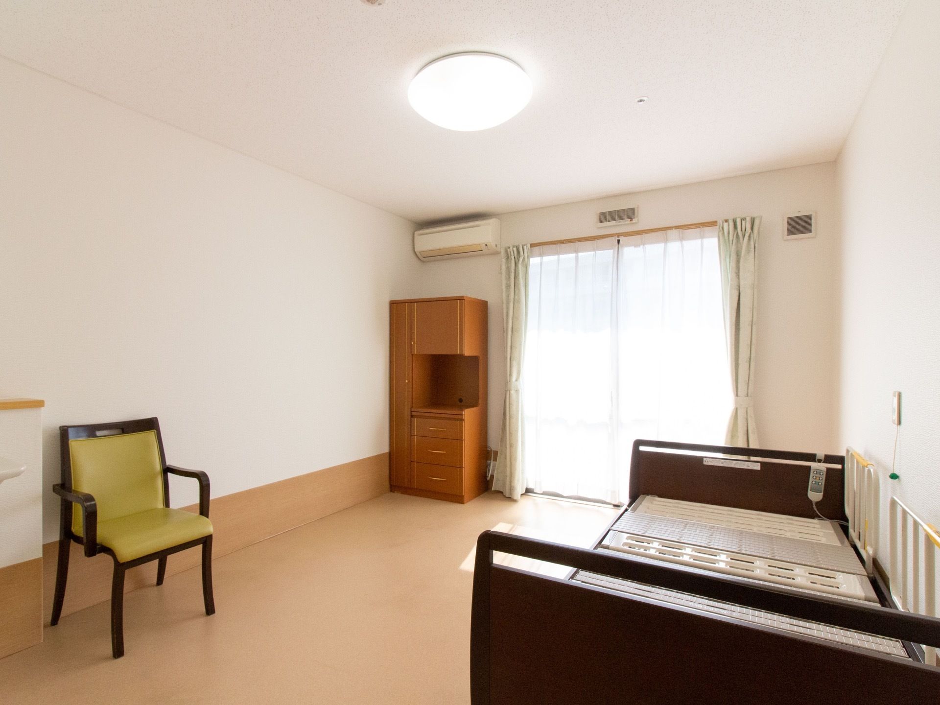 広々とスペースが確保されたご入居前の居室である。エアコンや介護用ベッドが設置されるなど、設備環境が整えられている。