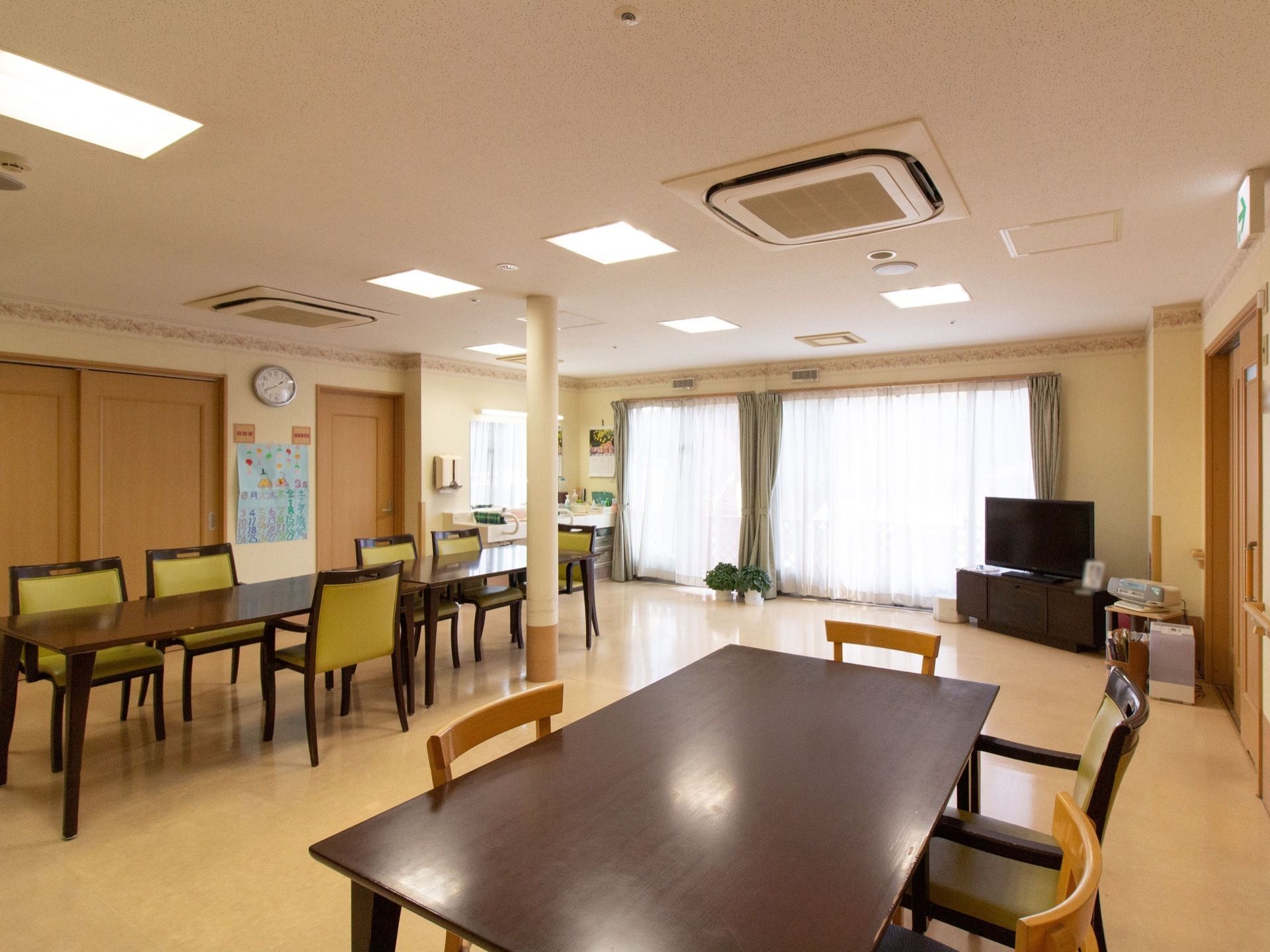 明るく広々とした室内は、あたたかみのある内装で、落ち着いた雰囲気である。部屋の中央にテーブルが配置され、通路幅にゆとりを設けている。