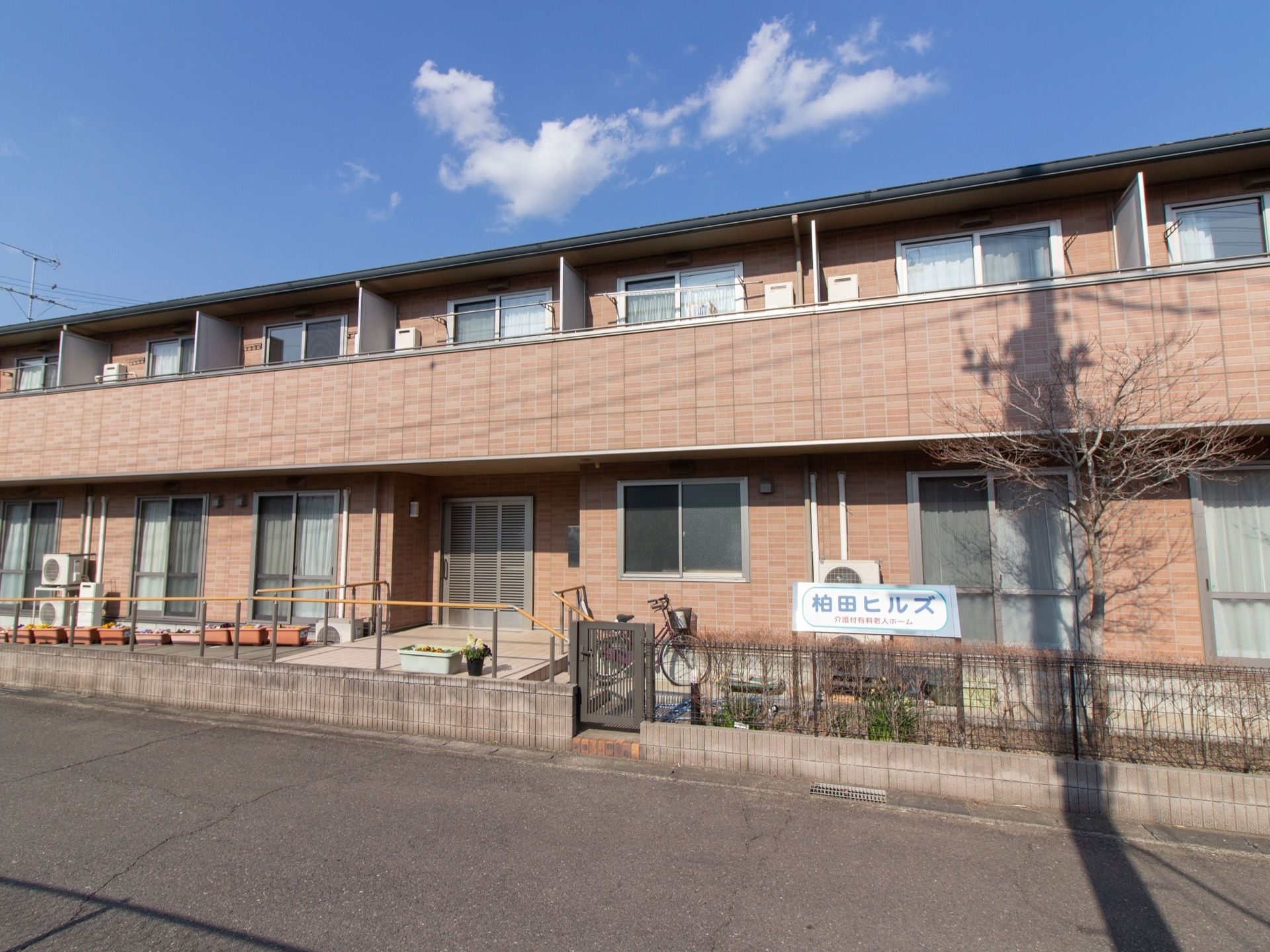 広い敷地を活用して、横に長く建てられている。２階建ての集合住宅のような外観で、エントランスにはスロープが設置されている。