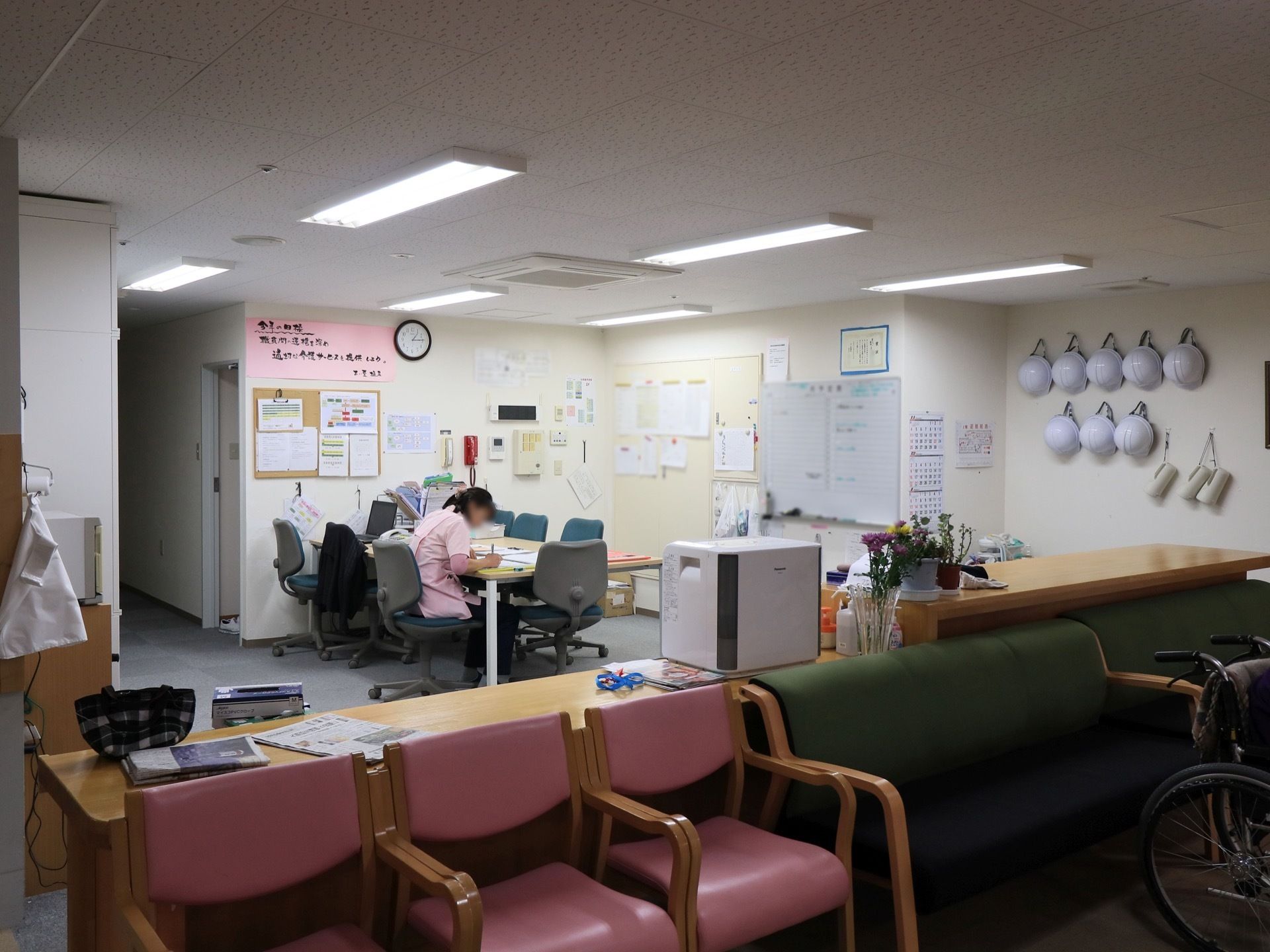 開放的なヘルパーステーションである。オフィスチェアがセットされたテーブルが置かれている。ソファがカウンターの前に置かれている。