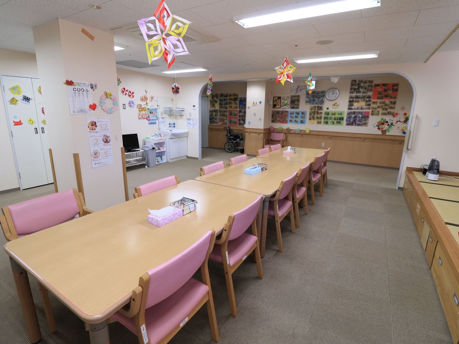 グレーのカーペットが敷かれた部屋にダイニングテーブルセットが並べられている。壁際には畳の小上がりもある。