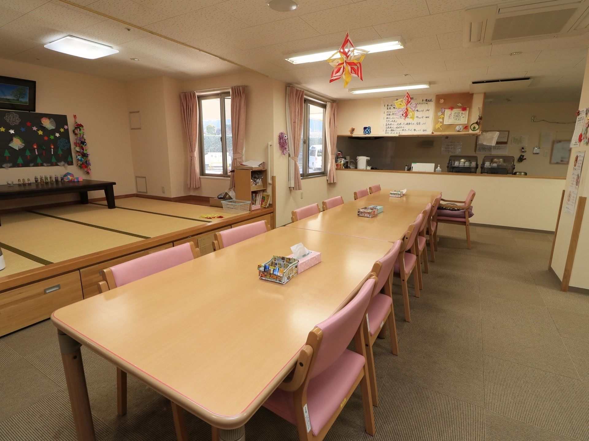 ダイニングテーブルが並べられた部屋の奥に、キッチンカウンターがある。カウンターには湯飲みやポットが置かれている。
