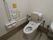 手すりと背もたれが取りつけられた広い洋式のトイレになっている。壁には緊急時のナースコールが設置されている。