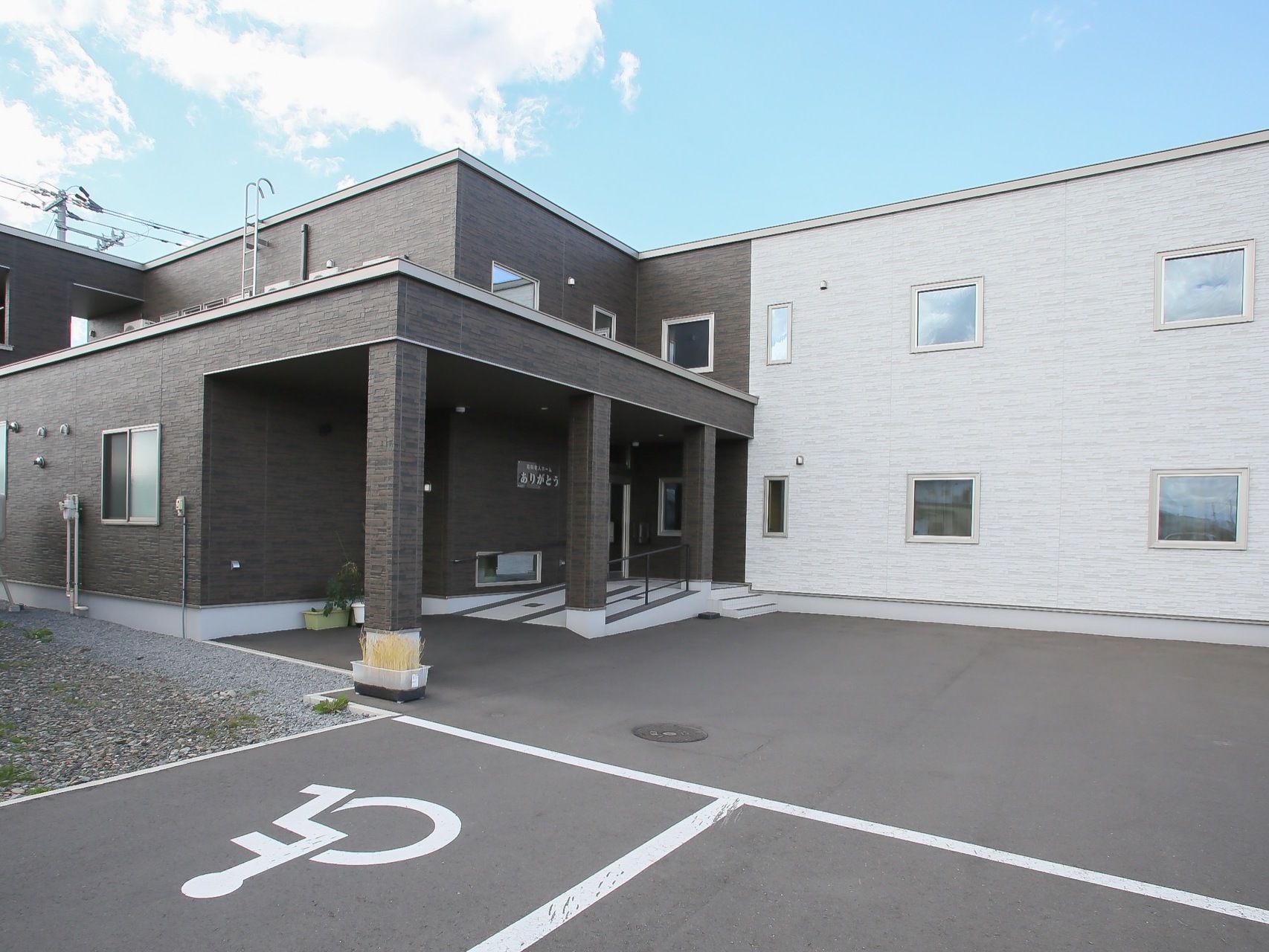 ブラウンとホワイトの２トーンカラーでまとめられた２階建ての施設である。玄関入口付近は緩やかなスロープが設置されている。