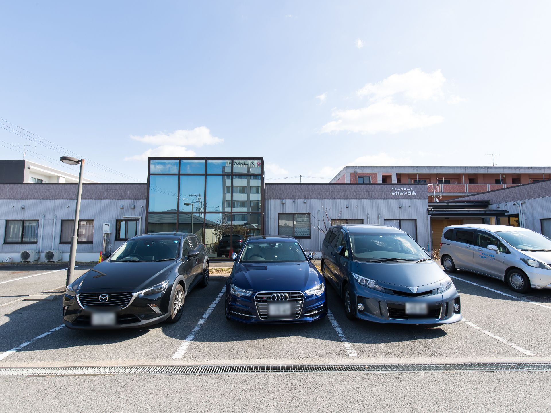 施設が完備している駐車場である。４台の車が停車している。遠方のご家族様にも気兼ねなく、お越しいただきやすい。