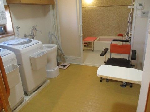 洗濯機が二台並んでいる、奥に浴室が見える広い脱衣所