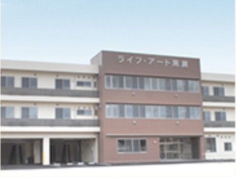 建物は３階建てで横長である。上部に施設名が書かれた中央部分は茶色の外壁で特に窓が多く、その両サイドは白い外壁でベランダも設置されている。