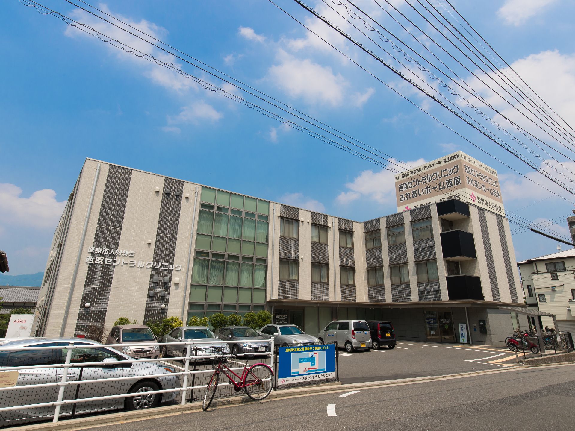 駐車場完備、玄関前に長い庇がついている三階建ての建物
