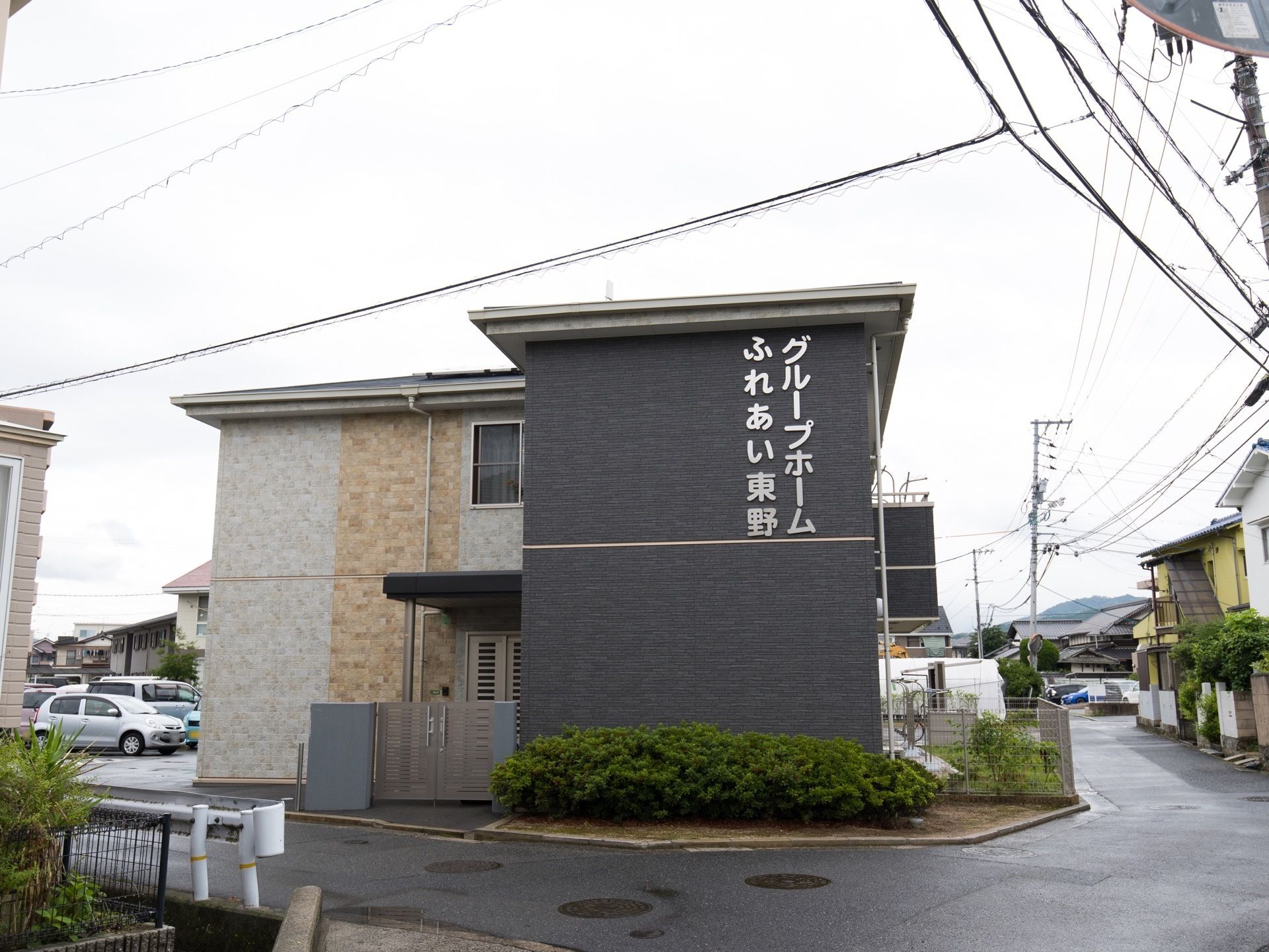 一軒家を思わせる外観である。出入口には門があり、駐車場とは段差なく続いている。２階にはベランダがある。