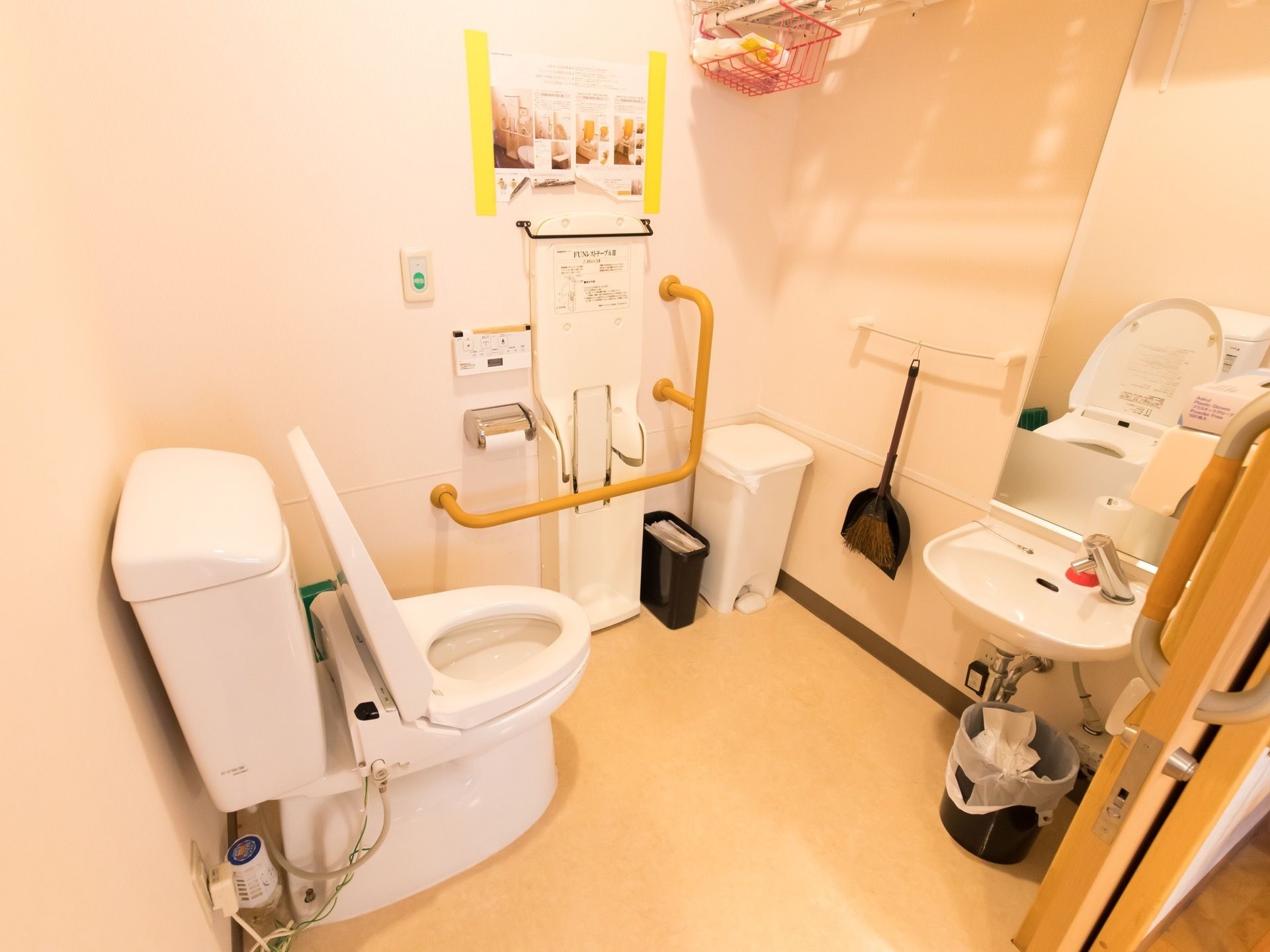 室内には、タンク付きのトイレと簡易洗面台が設置されている。壁には手すりが取りつけられており、ほうきも掛けられている。