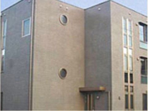 施設は、グレーの外壁で統一された外観となっている。壁には、丸い窓や縦に長い窓がたくさん取りつけられている。