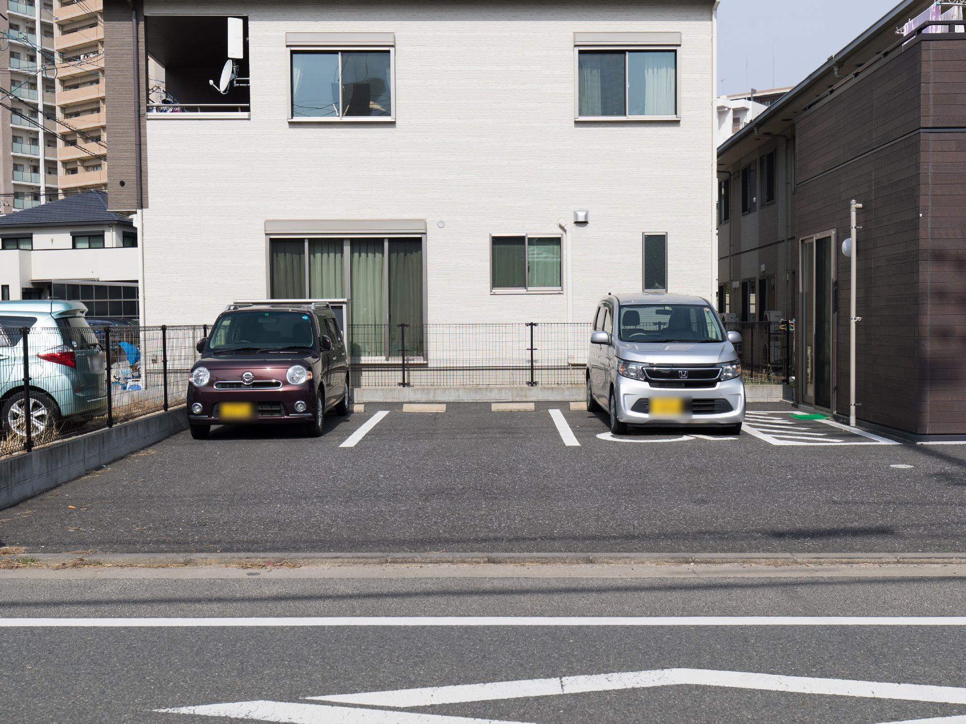 施設が完備している駐車場である。３台の駐車スペースが確保され、両端には車が停車している。施設建物から車にすぐ乗り込むことができる。