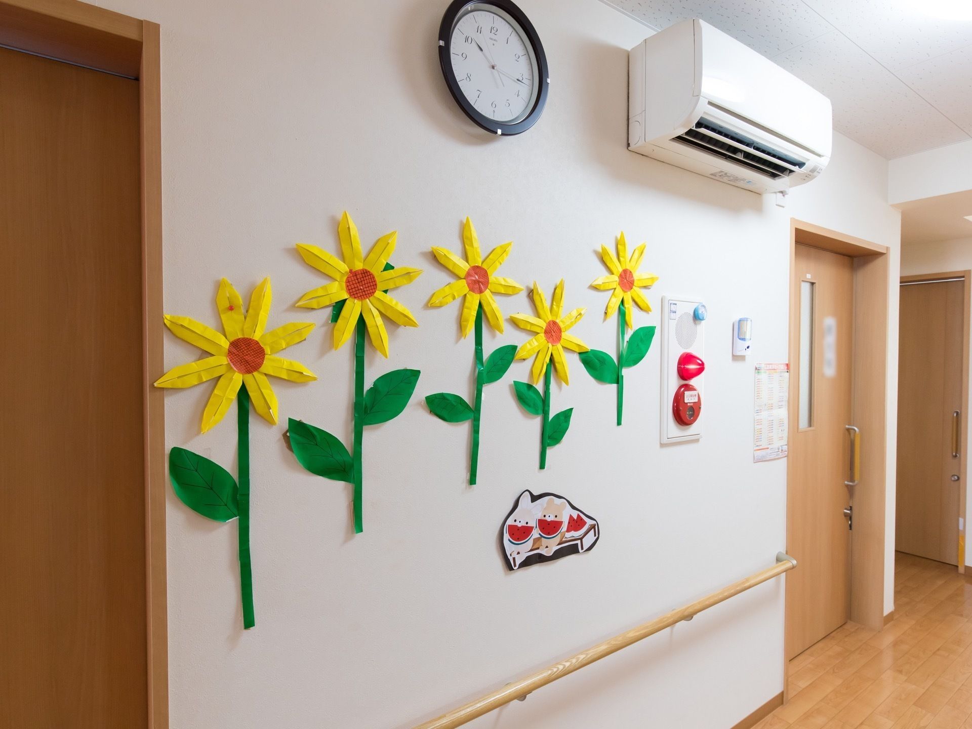 白い壁に貼られている、折り紙で作ってあるひまわりの花