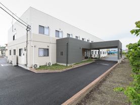 施設は２階建ての建物である。玄関前には大きな屋根があり、車をその場所まで乗り入れることができ、車での来訪も便利である。