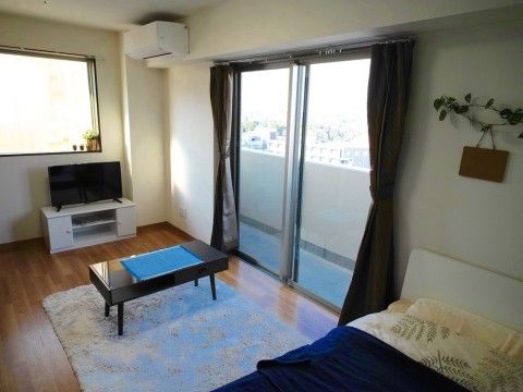 ベランダに出られる大きな掃き出し窓がある、明るい居室。フローリングと白い壁で、どんな家具にも合いやすいナチュラルな内装になっている。