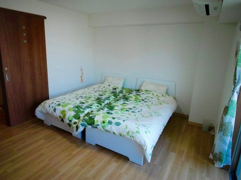ご夫婦での入居も可能な二人用の居室は、シングルベッドを２台並べても十分な広さがある。スライド式の室内扉は床が平坦で安全である。