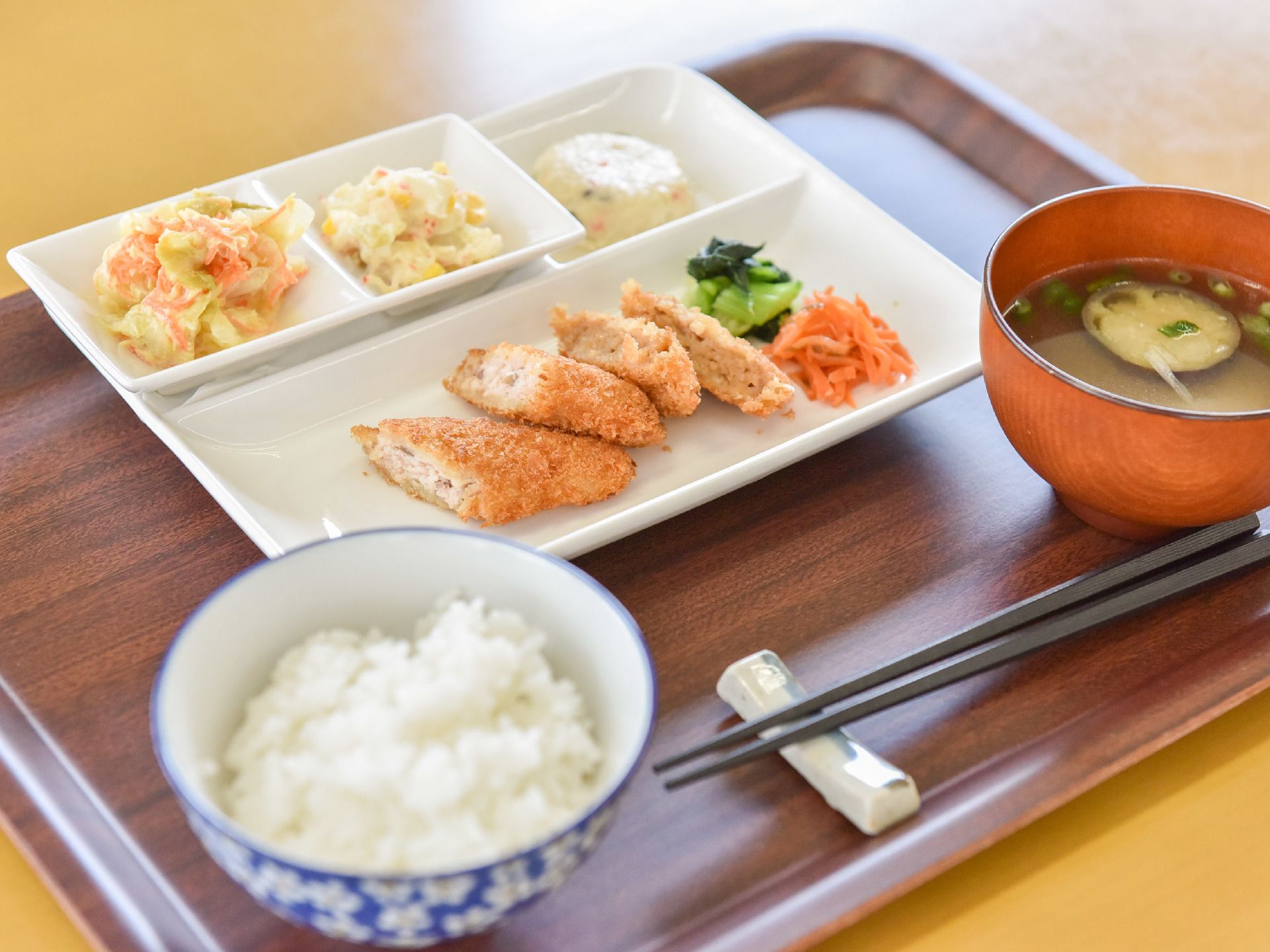 メインのおかずには肉の揚げ物がのっていて2品の野菜が添えてある。副菜には2品のサラダがあり、他に1品ある。