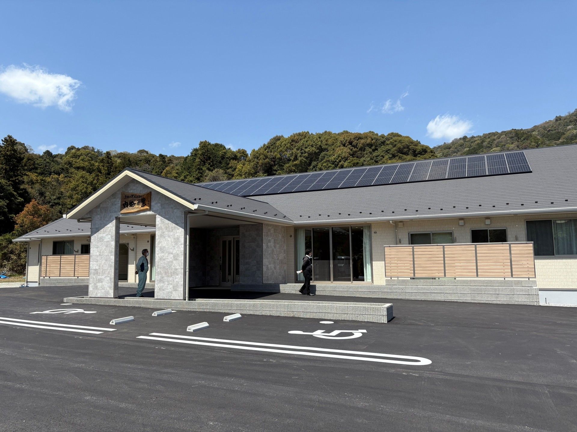 スロープがあり階段横に小さな花壇が作られている、平屋建て