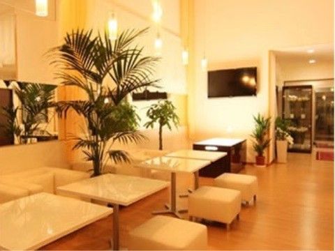 観葉植物がありソファとテーブルの並んだ、大型テレビのあるリビング