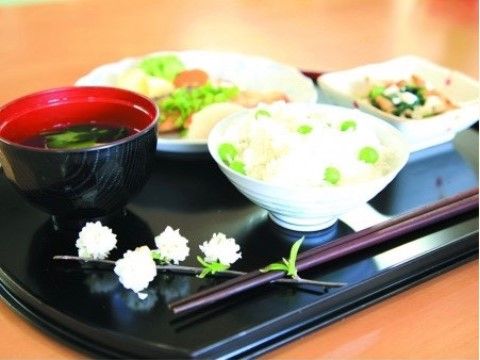 花飾りが箸置きになっている、豆ごはんの盛り付けられたお膳