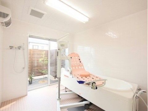 壁や天井が白色のタイルになっている浴室には、大きな窓がありとても明るい。寝た状態で入浴できる機械浴槽が完備されている。