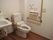 洋式のトイレの個室で、壁にはＬ字型、便器の右側には可動式の手すりが備わっている。個室内には洗面台が併設されている。