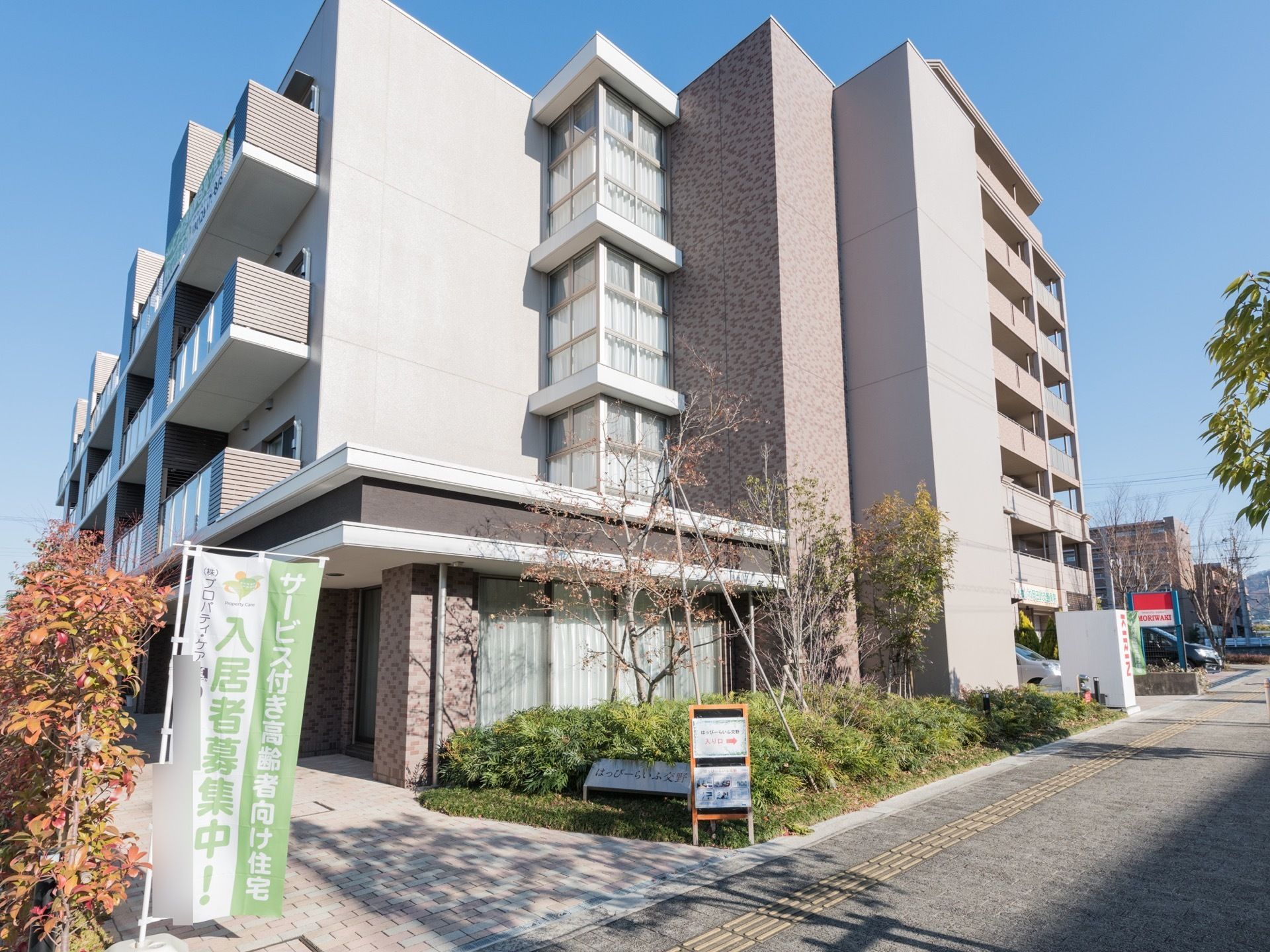 四階建てで奥行きがある。開放感があり、部屋からの景色がよく見渡せる。落ち着いた色のシンプルな建物で、都会的なイメージである。