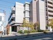 施設は落ち着いた雰囲気の建物となっている。入居者募集中ののぼりが立てられている。たくさんの植物が観賞できる。