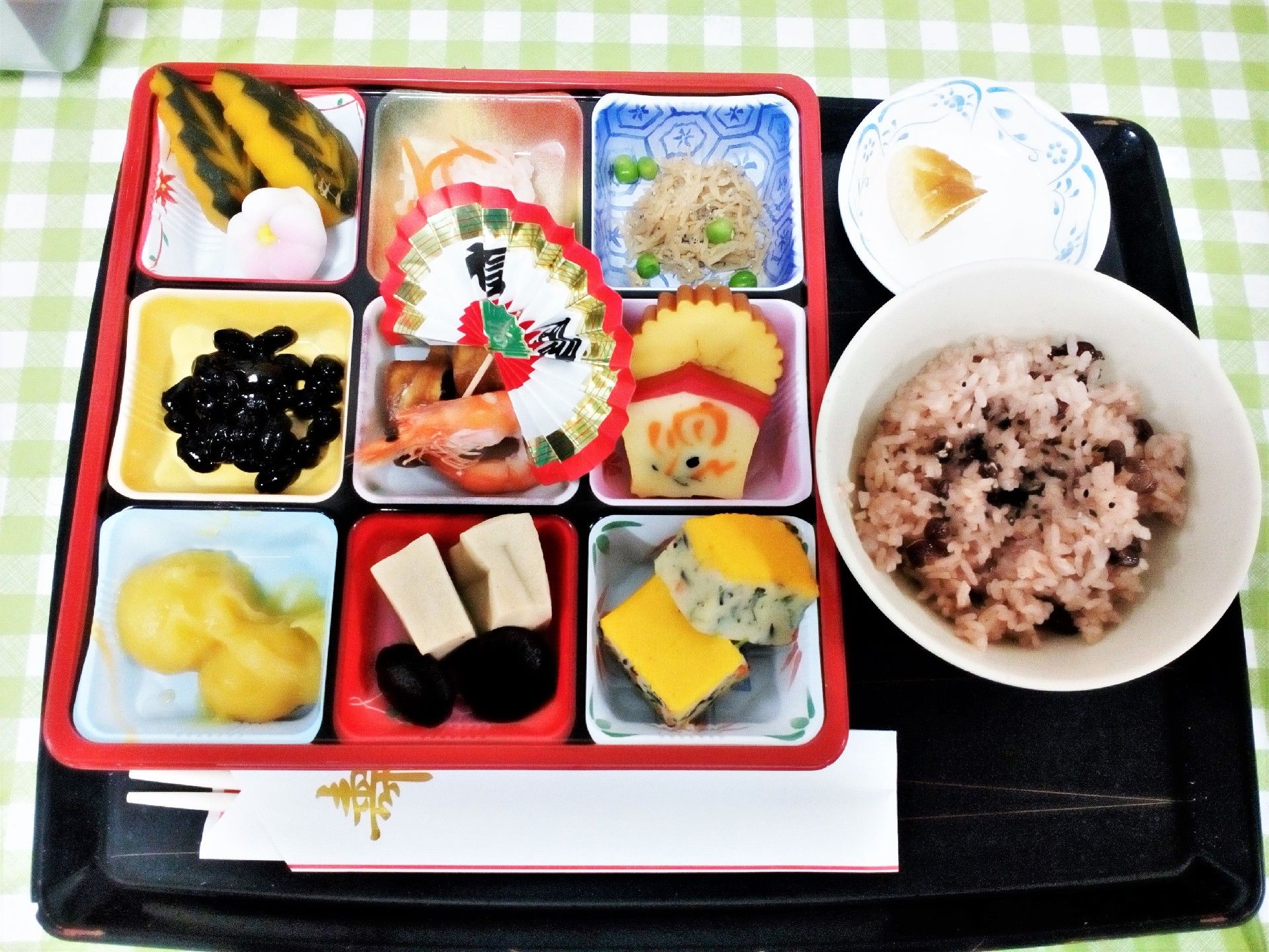 トレイに赤飯と9種類の料理が並べられている。専属の料理人が栄養のバランスを考えて毎食調理している。