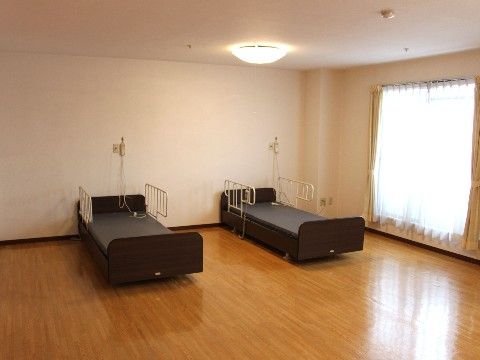 白塗りの壁際に二つのベッドが設置されている、二人向けの居室