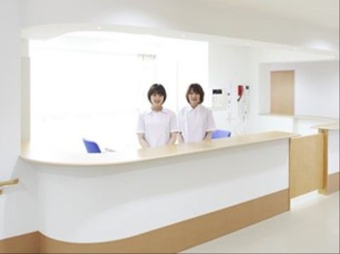 笑顔の女性スタッフ二名が立っている、受付カウンター