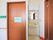 共有のトイレで、横の壁の表示のほかに、扉に貼られた紙にもトイレと大きく書かれている。右側に洗面台が備わっている。