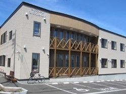 ２階建ての建物の外観写真。ベランダのような場所があるデザイン性の高い建物