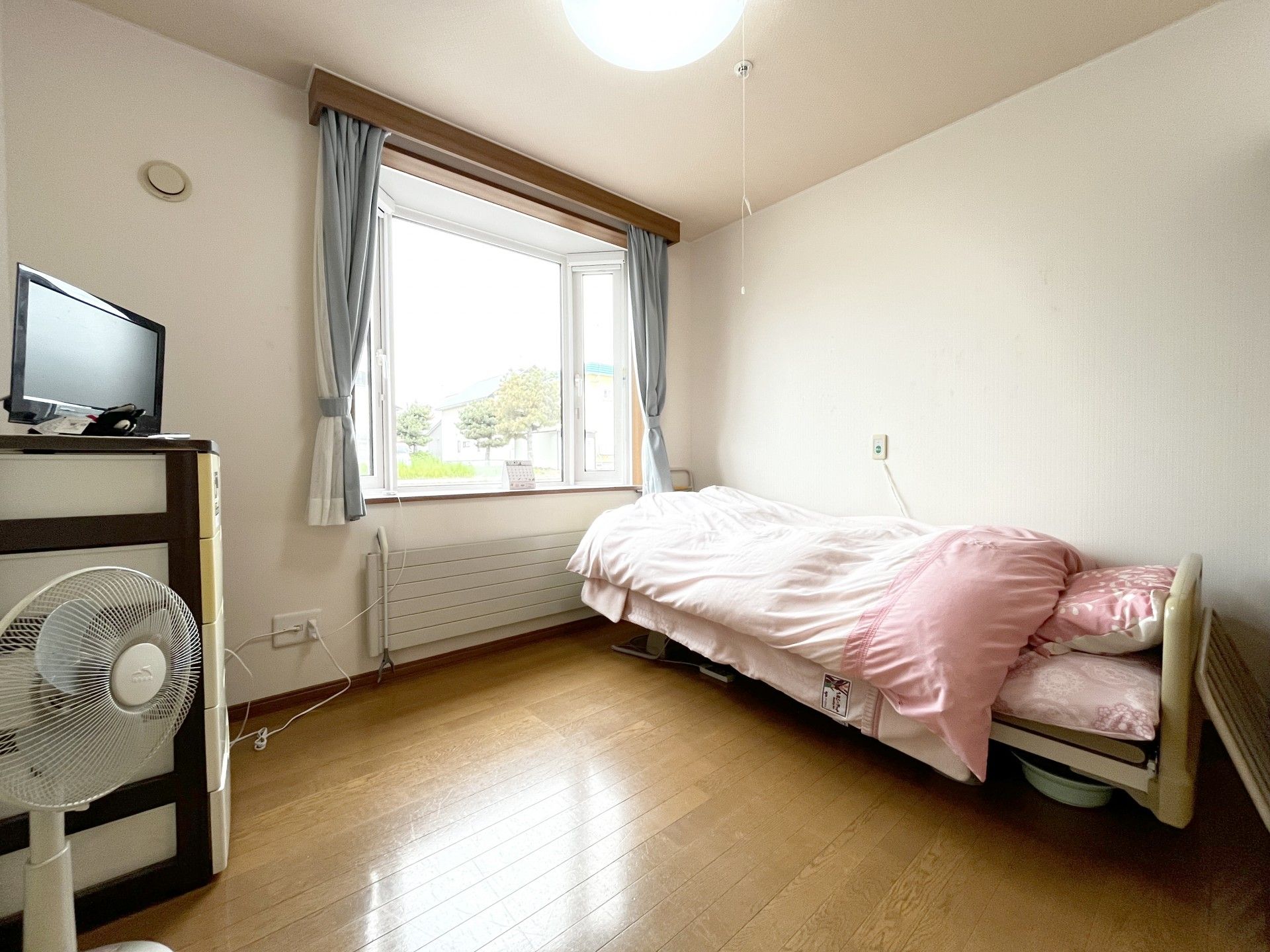 車いすに乗った女性を押す家族の男性とそこに寄り添う介護スタッフの様子