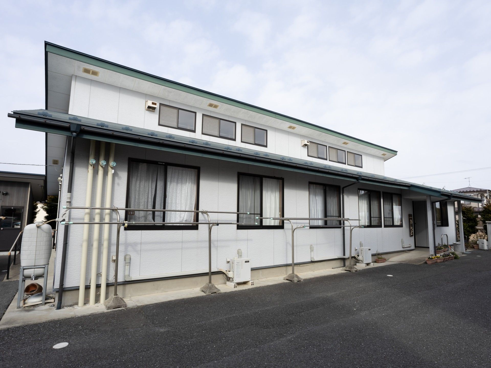 広々とした白い一階建て建物