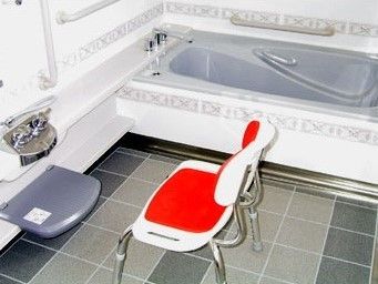 大きめのシャワーチェアが置いてある施設内の浴室。一人で入浴するタイプの通常の浴槽