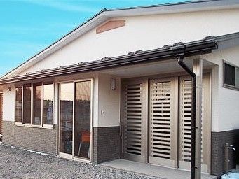 平屋建ての大きな建物の様子。大きな窓とフラットなエントランス部分が写っている写真