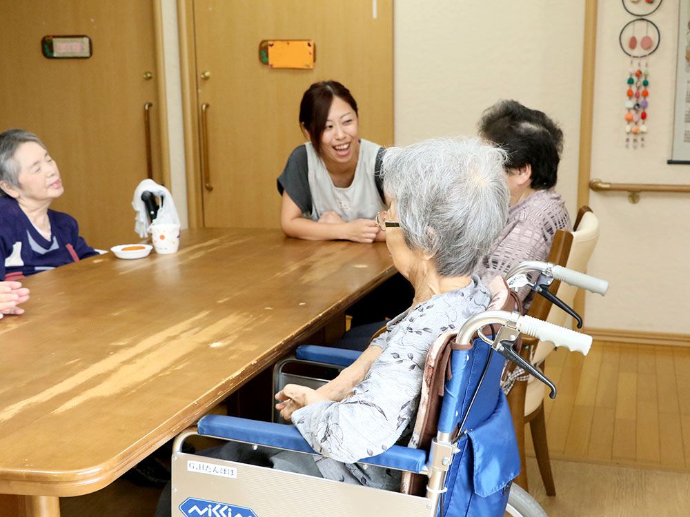 リビングに集まってだんらんしているスタッフと高齢者の様子