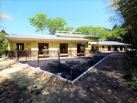 平屋建ての建物で駐車場もあり、周辺には木が植えられている。一般家庭のような雰囲気。