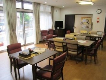 天井まである大きな窓がある部屋に、並べられたテーブルと椅子