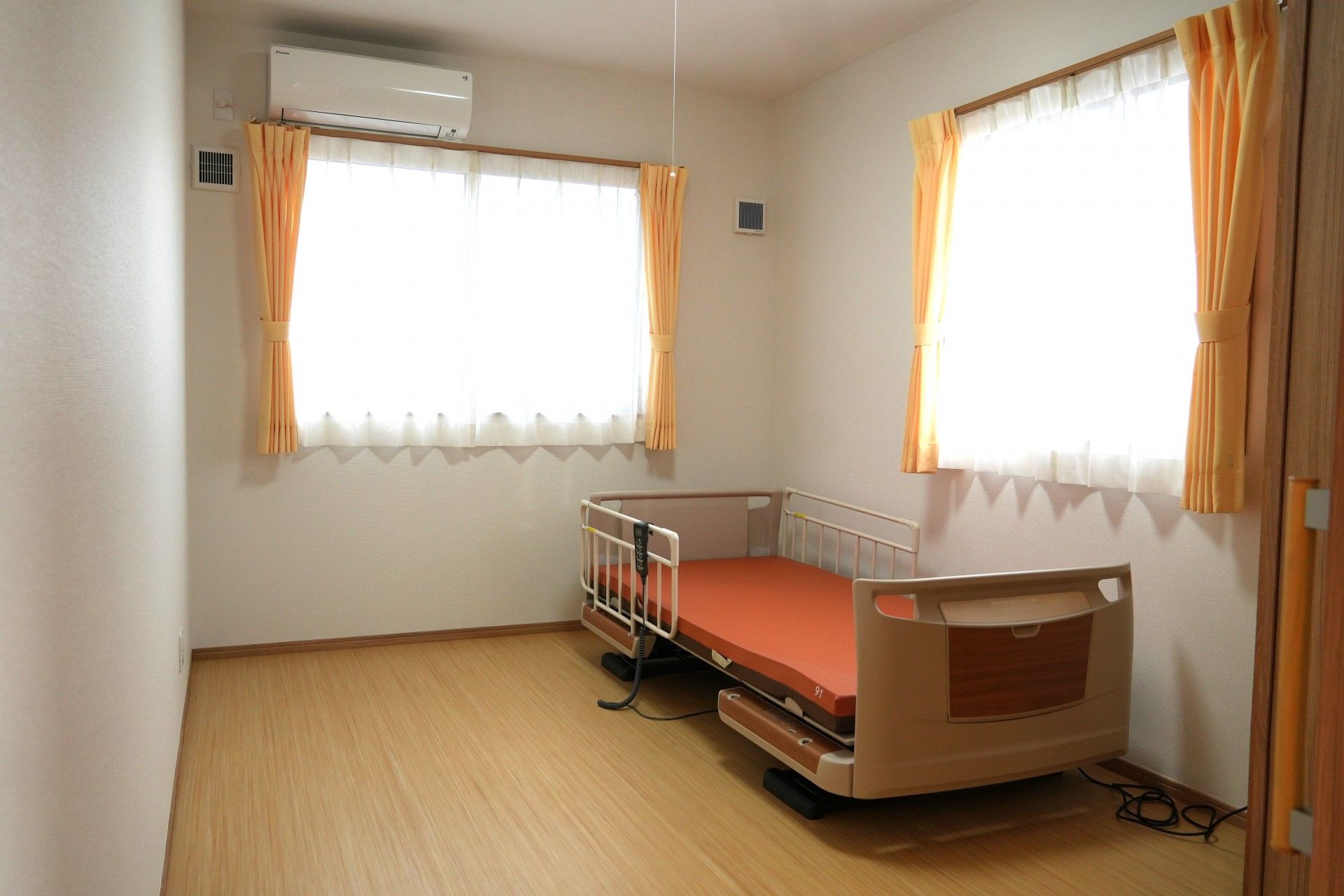 右側にベッド、左側に一人用の机と椅子がある小さなワンルームタイプの部屋