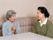 高齢者と笑顔で会話を交わしているスタッフ。笑顔で話している様子