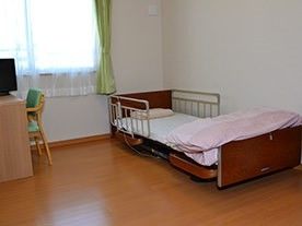 ベッドやテレビ、机、いすなどが並べられている施設の居室の様子