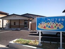 高さを抑えた高齢者向け施設の外観と駐車場付近。青空が広がる天気が良い日の写真