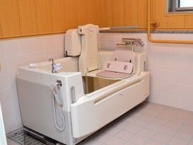 介護仕様の浴槽が置いてある広めの浴室の様子。手すりがついた近代的な浴室