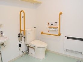 両側に手すりがついた介護仕様のトイレの様子。可動式の手すりがついている