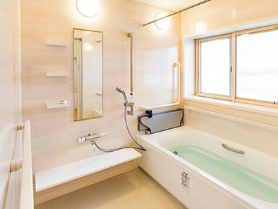 横に長い浴槽がある一人用の通常浴室。手すりがついている様子