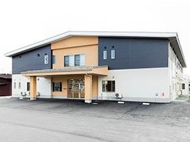 ツートンカラーの落ち着いた雰囲気の建物。シンプルで機能的な玄関付近