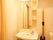 居室のトイレには洗面台がある。大きな鏡で収納ポケットがついた使いやすい物である。コンセント口もあり、便利に使用できる。