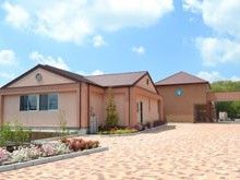 平屋建ての建物は外国の建物のようなたたずまい。季節の花がきれいに咲いたスペースもある。